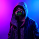 A hoodie-wearing man shows off Razer's Zephyr air filtration mask looking very much like a cyberpunk character.